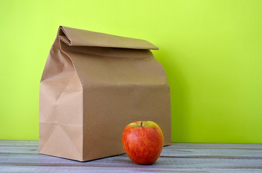 午餐装在牛皮纸袋里，配红苹果