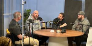 Four men sitting around a table talking